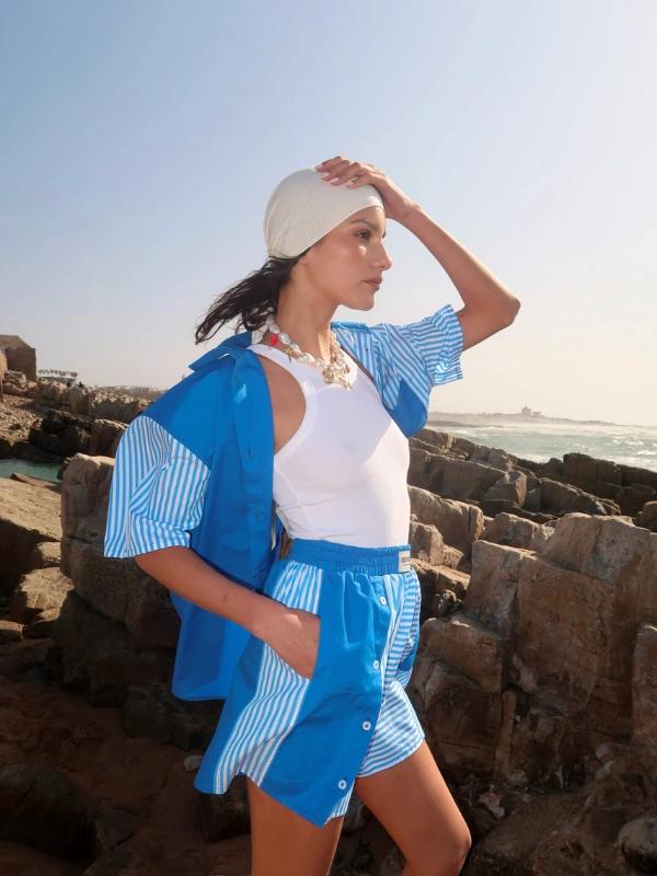 Short pachwork bleu - Liam Taille haute avec une ceinture élastique de 4,5 cm, il offre une coupe ample et confortable, parfaite pour les journées d’été. Confectionné à partir de 2 tissus différents issus de stocks dormants, il s’inscrit dans une démarche d’upcycling et d’originalité. Détail signature : une patte de boutonnage sur la jambe droite, que l’on peut laisser fermée ou entrouvrir selon l’envie. À porter seul ou en total look avec la chemise Liam assortie, pour une silhouette forte et colorée.