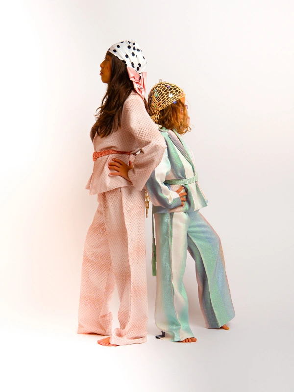 Succombez au charme de notre tailleur oversize fluide pour petites princesses. Fusion parfaite entre modernité et inspiration marocaine, il s'adapte avec style à toutes les occasions, des moments simples aux grands événements. Conçu dans un brocart scintillant, tout en offrant un confort absolu et pour embellir la tenue, un Mejdoul fait main pour structurer et sublimer la silhouette de vos mini-muses. Disponible en version matchy-matchy pour les duos de sœurs et les complicités Maman-Princesse.