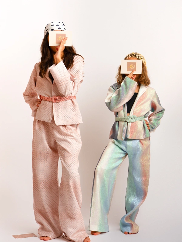 Succombez au charme de notre tailleur oversize fluide pour petites princesses. Fusion parfaite entre modernité et inspiration marocaine, il s'adapte avec style à toutes les occasions, des moments simples aux grands événements. Conçu dans un brocart scintillant, tout en offrant un confort absolu et pour embellir la tenue, un Mejdoul fait main pour structurer et sublimer la silhouette de vos mini-muses. Disponible en version matchy-matchy pour les duos de sœurs et les complicités Maman-Princesse.